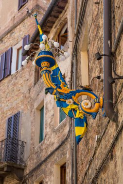 Siena Italy July 1st 2015 : Palio flag and ornate lighting in a  street in Siena, Tuscany clipart
