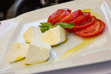 Buffalo mozzarella peyniri, domates ve fesleğen salata sızma zeytinyağı ile giyinmiş.