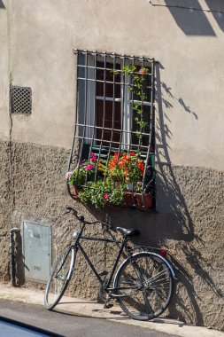 Windowbox Lucca, İtalya için çiçeklerle çubuklu penceresinin altındaki Bisiklet Park