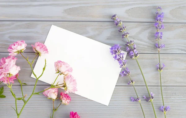 Einladungsattrappe mit Lavendel und Rosenblüten über graue Holzpaneele. ehrfürchtige Design-Vorlage — Stockfoto