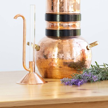 Distilling apparatus alembic with esential oil flowers. clipart