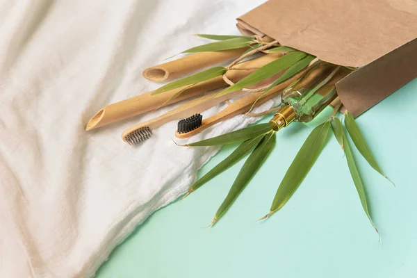 Composição ecológica com escova de dentes, saco de papel, ramos de bambu e toalha branca de fibras de bambu — Fotografia de Stock
