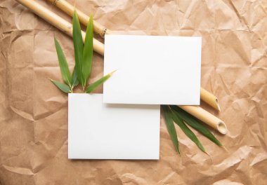 Bambu dalları ve buruşuk kağıtlar üzerinde beyaz zarf pankartı.