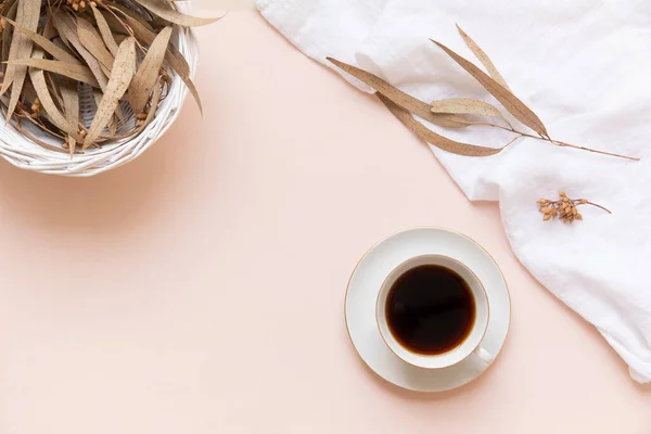 Foglie di eucalipto e una tazza di caffè nero su uno sfondo chiaro con spazio vuoto. — Foto Stock