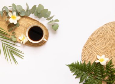 Taze tropik yapraklı bir fincan sade kahve..