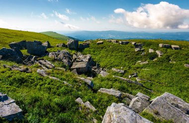 çimenli yamaca kayalık oluşumu. Yaz aylarında güzel doğa manzarası