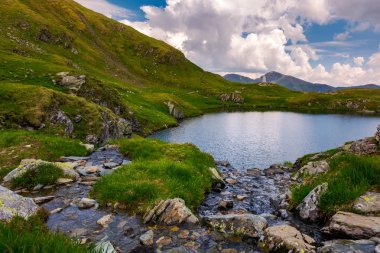 hızlı akarsu akışı için göl Capra dağlarda. Fagaras dağ sırtı altında mesafede muhteşem cennet. Güzel yaz manzara Romanya