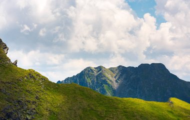 kayalık ridge bulut altında çimenli tepe arkasında. Yaz aylarında güzel dağlık manzara