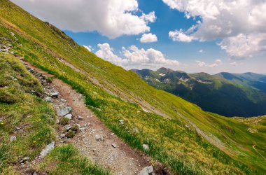 Fagaras Dağı çimenli eğimi ile turist yolu. güzel yaz manzara bulutlu gökyüzü altında