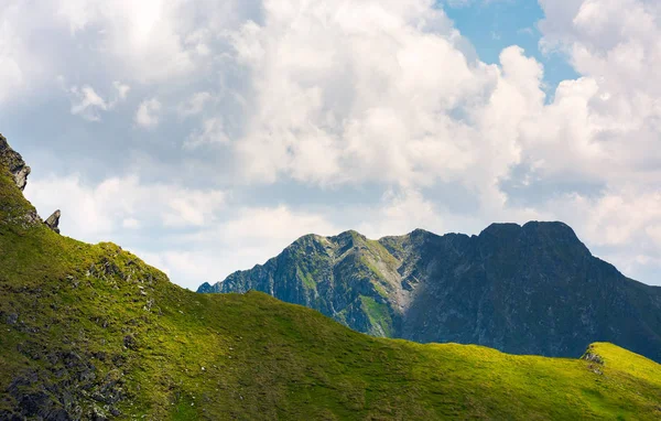 kayalık ridge bulut altında çimenli tepe arkasında. Yaz aylarında güzel dağlık manzara