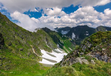 Fagaras Vadisi Dağları kayalıklardan. bulutlu bir günde güzel yaz sahne. kar çimenli yamaca noktalar. Romanya'nın güzel manzara