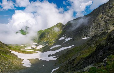 kar kayalık uçurum ile vadideki noktalar. uzak dağ tepe bulut oluşumu. muhteşem yaz sahne üzerinde bir yüksek irtifa