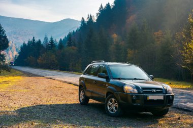 Mizhhirya, Ukrayna - 21 Ekim 2017: Hyundai Tucso 2010 Suv ormanlık dağ yol tarafında. sisli sonbahar gündoğumu üzerinde güzel ulaşım sahne. Araba kavramı ile seyahat