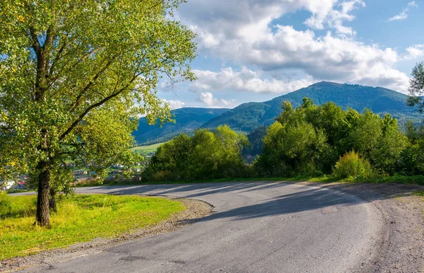 serpantin dönüş azalan. ağaçlar eski asfalt ülke yol boyunca. Uzaktan güzel dağ sırtı görünümünü açar