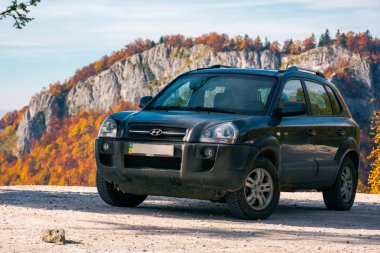 Vartop, Romanya - 15 Ekim 2017: Hyundai Tucson Suv dağlarda yolda. kırmızımsı renkli yeşillik uzakta kayalık kayalıklardan. güzel sonbahar sahne. Araba kavramı ile Avrupa'yı gezersin