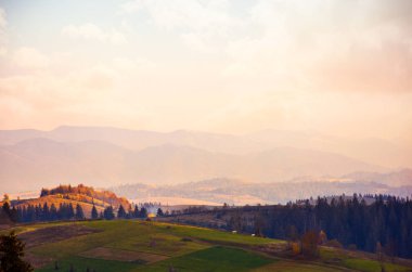 Puslu Dağlar akşamları. güzel kırsal kesimde sonbahar. sıcak hava ile pembemsi bulutlar gökyüzü üzerinde