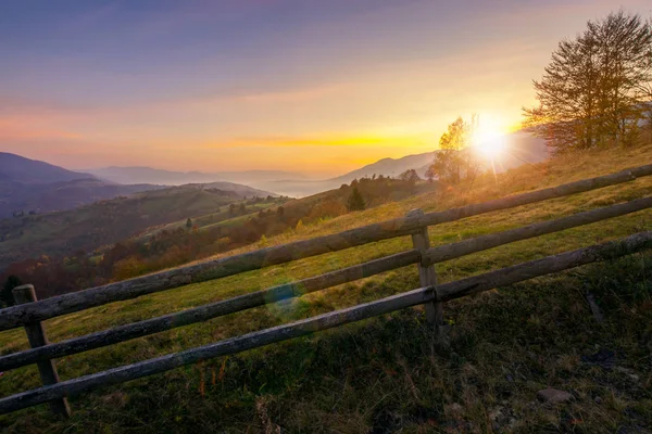 美丽的日出在山上 秋天的乡村风光 沿着农村的围栏 阴霾中的远方山脉 — 图库照片