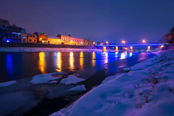 乌克兰乌日哥罗德 2016年12月26日 冬季欧洲老城乌日哥罗德美丽的晚间城市景观 美妙的多云的天空在乌兹河与一些冰雪岸边 城市景观反射在水面上 — 图库照片