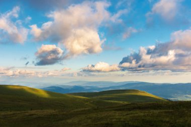 Harika akşam manzara. çimenli tepeye güzel manzara uzak Vadisi ve dağ sırt. kabarık bulutlar gökyüzü üzerinde. huzurlu pastoral sahne