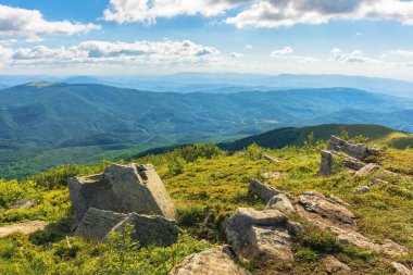 çimenli Alpin çayır üzerinde taşlar. güzel yaz manzara dağlarda. Harika güneşli hava. kabarık bulutlar gökyüzü üzerinde. uzak ridge görüntülemek