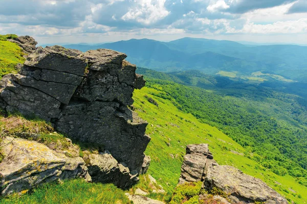 Obrovské skalnaté útvary na travnatých kopcích — Stock fotografie