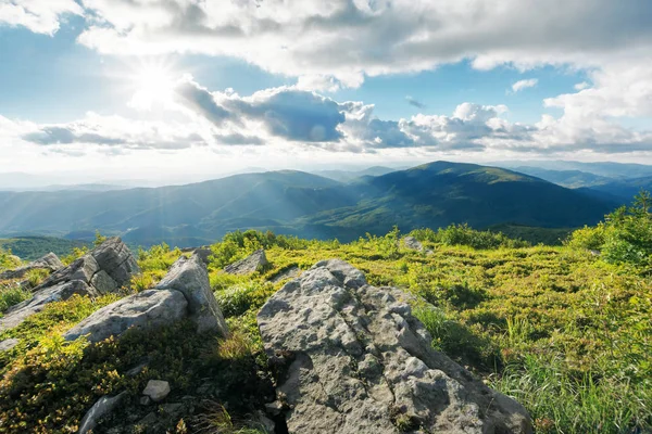 Rocce sul prato erboso montagne al tramonto — Foto Stock