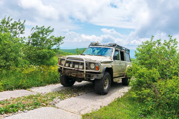 Vecchio fuoristrada sulla strada di montagna asfaltata — Foto Stock