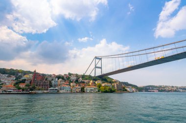 İstanbul, Türkiye - 18 AUG 2015: Boğaz üzerindeki Fatih Sultan Mehmet Köprüsü. Güneşli bir yaz gününde sudan gözlemlenen güzel bir tarihi şehir manzarası. Yumuşak bulutlu sakin bir hava