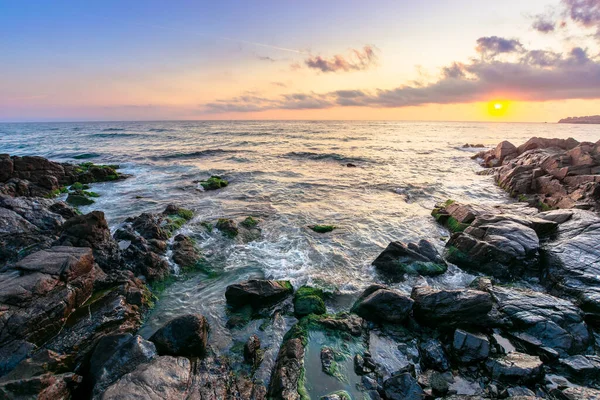 日没時に海の海岸 水の中の岩と美しい風景 太陽と地平線の上の豪華な雲 平静と調停という概念は — ストック写真