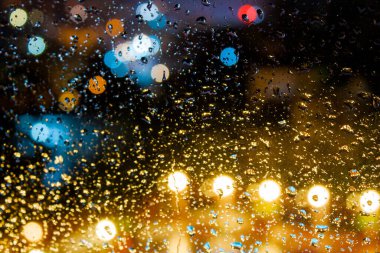 Gece lambası ıslak pencerenin arkasında. soyut bulanık arkaplan