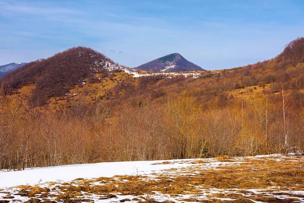 山の風景の中の春 草原の白樺の木や雪のはかなさ 遠くの尾根だ 青空に雲の多い晴天 — ストック写真