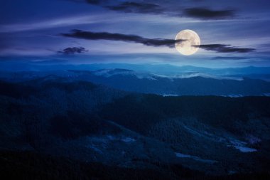 Bir yaz gecesinde dağ manzarası. Tepeler vadiden uzak tepeye doğru yuvarlanıyor. Dolunay ışığında yaz manzarası