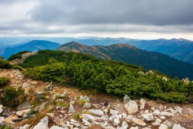 Bir dağın tepesinden manzara. Bulutlu sonbahar manzarası. Vadinin arkasındaki sıradağlarda. Renkli manzarada dramatik hava
