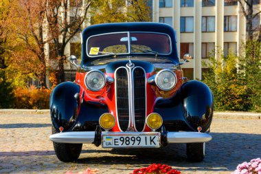 Uzhhorod, Ukrayna - 31 Ekim 2021: Siyah başlıklı kırmızı bmw 321 'in ön görüntüsü. 40 'lı yılların klasiği. Sonbaharın güneşli bir gününde Narodna Meydanı 'nda klasik araç sergisi