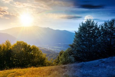 Sonbahar ekinoksu sırasında tepesinde orman olan dağ manzarası. Gündüz ve gece zaman kavramını değiştirir. Kırsal vadiye güzel bir manzara. Alacakaranlıkta güneş ve ayın olduğu dağlık arazi manzarası