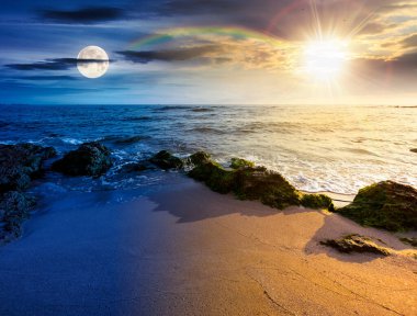 Kumsalda kum var. Gündüz ve gece zaman kavramını değiştirir. Deniz kenarında yaz gündönümü. Güneşin altında sakin dalgalar ve alacakaranlıkta ay olan güzel deniz manzarası. Gökyüzünün altında kabarık bulutlarla deniz manzarası