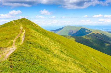 Yaz aylarında dağ turizmine giden yol. Ukrayna 'nın alp manzarası. Borzhava tepesinin güzel manzarası, mavi gökyüzünün altında bulutlu yeşil tepeler.