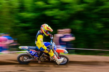 Uzhhorod, Ukrayna - 21 Mayıs 2017: MX sürücüsü köşeyi dönüyor. Motokros ormanın içinden geçiyor. Hızlanırken uçan toprakla yapılan aşırı spor