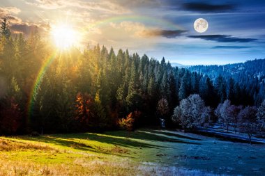 Sonbahar ekinoksu manzarası ormanın yakınındaki vadide yol boyunca renkli ağaçlarla. Gündüz ve gece zaman kavramını değiştirir. Dağlardaki güzel kır manzarası. Güneş ve ayın olduğu manzaralı bir yer.