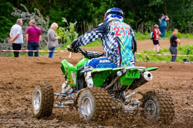 Uzhhorod, Ukrayna - 21 Mayıs 2017: ATV sürücüsü toprak yolda hızlanıyor. Çamurdaki yeşil dört tekerlekli aracın spor müsabakası