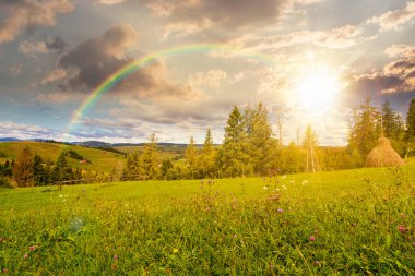 Kırsal alanda sonbaharda gün batımında. Manzaralı. Gökkuşağının altında yuvarlanan tepelerin olduğu kırsal bir manzara. Akşam ışığında dağ manzarası. taşra macerası