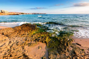 Tatlı mevsimde kumlu bir kumsalda gün doğumu. Karadeniz kıyılarında güzel ve sıcak bir hava var. Sozopol Sahili Sabah Işığı