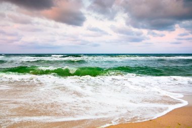 Ufuk üzerinde bulutlu gökyüzü ile dramatik deniz manzarası. Karamsar atmosferli bir tatil felaketi. Sonbaharda kıyılarda doğanın güzelliği ve tehlikesi