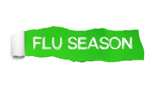 O texto FLU SEASON escrito sob o pedaço enrolado de papel rasgado verde — Fotografia de Stock