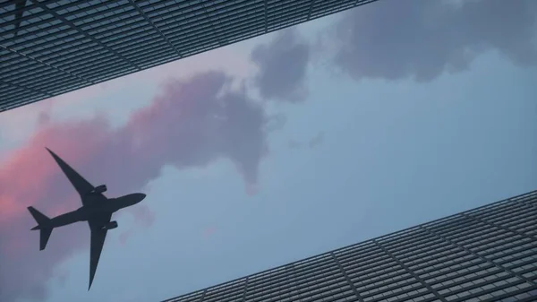 飛行機は高層ビルのオフィスビルの上を飛んでいます。3Dイラスト — ストック写真
