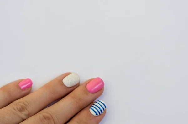 女性手与一个温和的彩色指甲在白色背景明亮多彩多姿的指甲设计 — 图库照片
