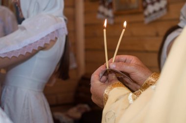 Rahip mumlar kilisenin içinde tutar.