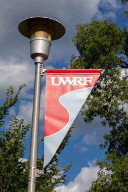 RIVER FALls, WI / USA - 4 AĞUSTOS 2020: Wisconsin River Falls Üniversitesi kampüs bayrağı ve ticari marka logosu.