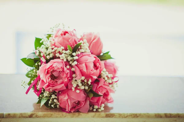 Yaz aylarında pembe peonies yalanlar bir mermer levha üzerine gelin buketi