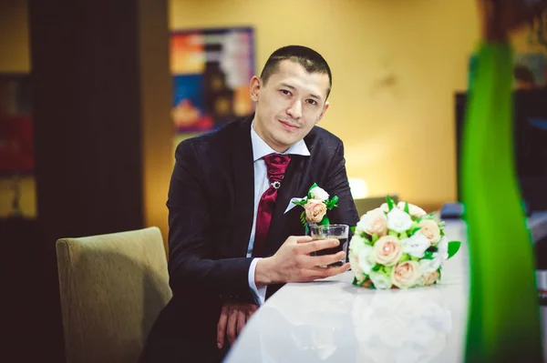 Bir bardak viski bar kırmızı kravatlı koyu takım elbiseli damat counter kapat